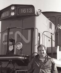 Charles Bohi stands in front of a parked train car.